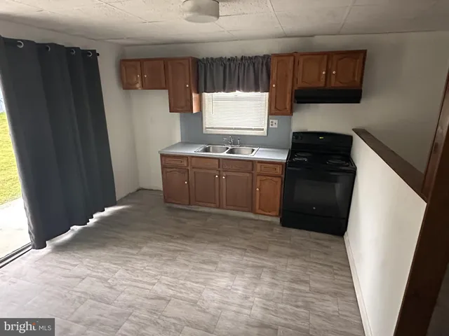 a kitchen with granite countertop a refrigerator and a stove