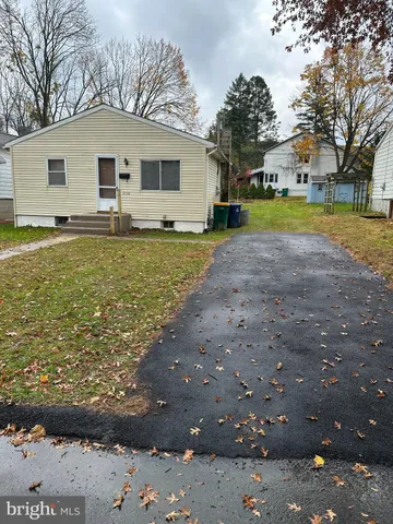 a front view of a house with garden and trees