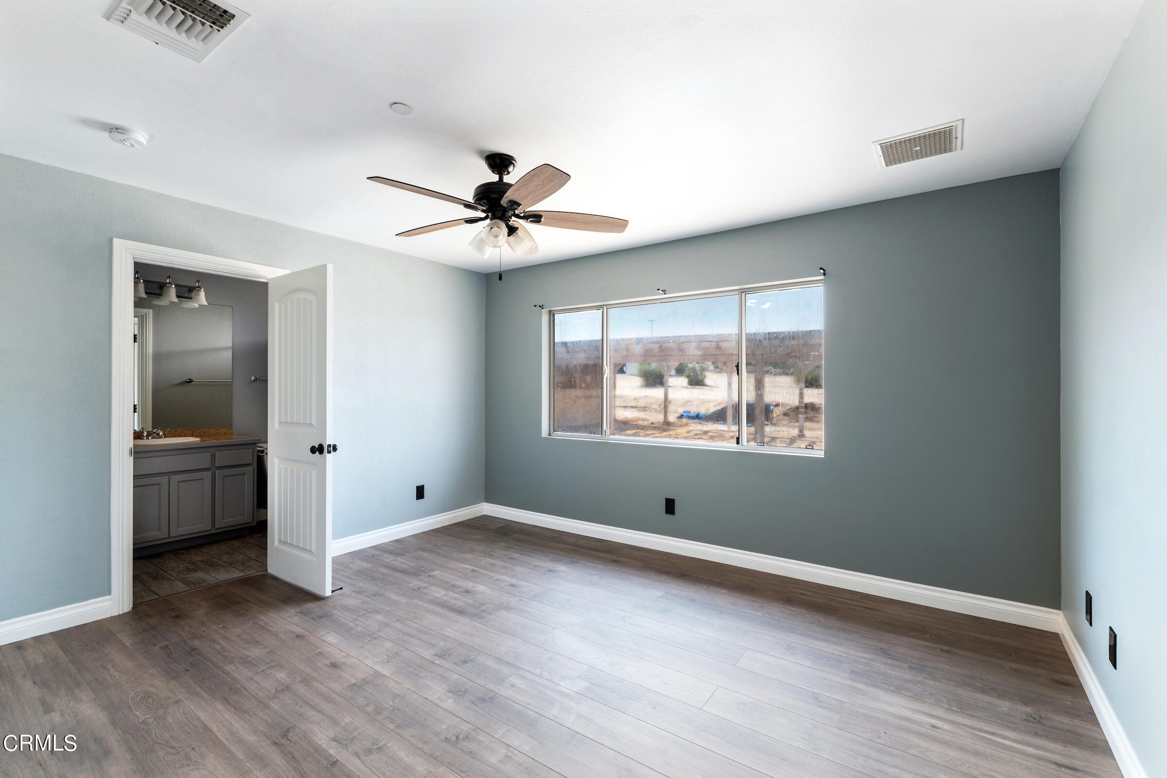 6864 Sunnyhill Road Joshua Tree, CA 92252 - Photo 40 of 71 an empty room with wooden floor and windows