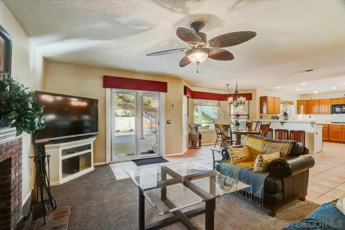 14381 Silver Heights Road Poway, CA 92064 - Photo 18 of 56 a living room with furniture a flat screen tv and a floor to ceiling window