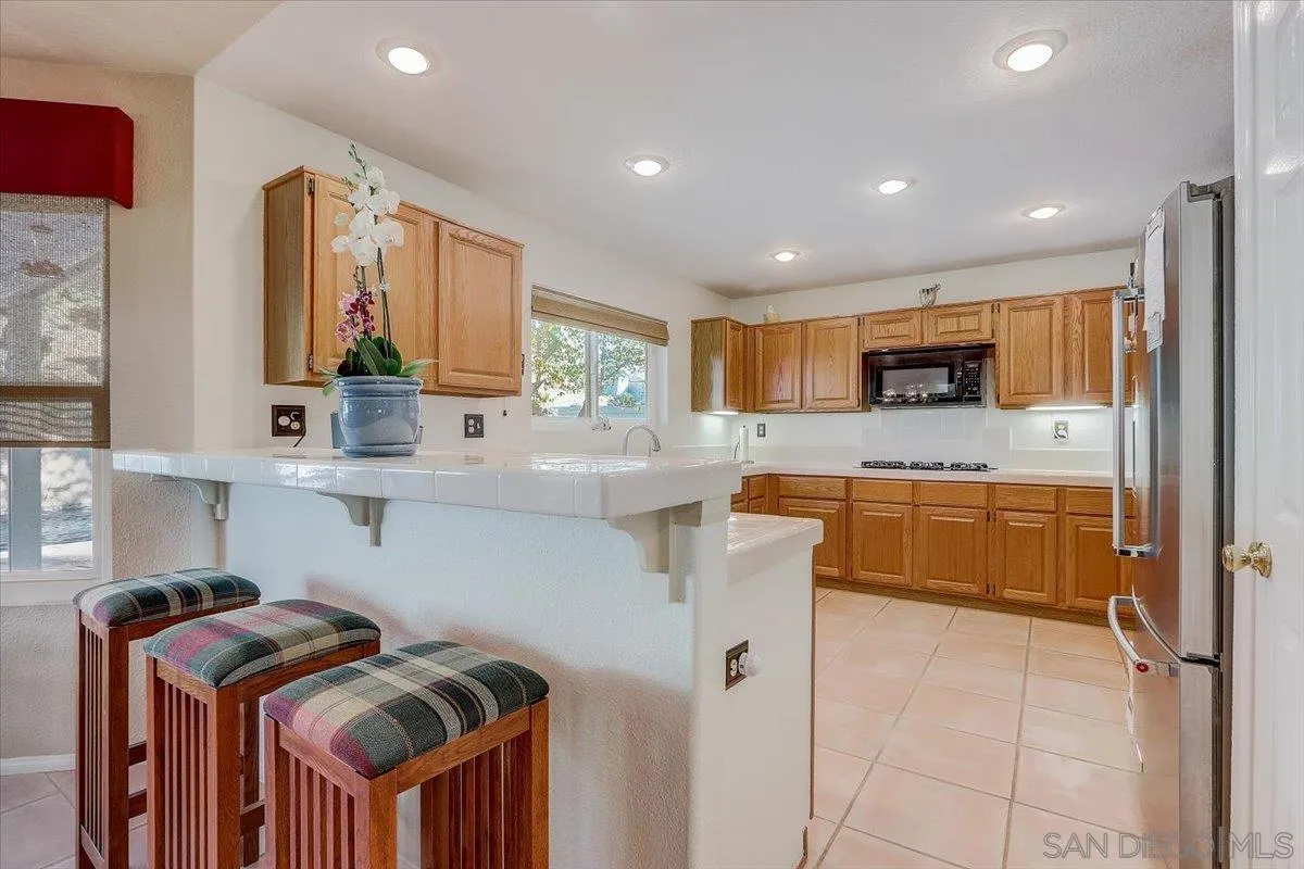 14381 Silver Heights Road Poway, CA 92064 - Photo 24 of 56 a kitchen with granite countertop a sink a counter top space stainless steel appliances and cabinets
