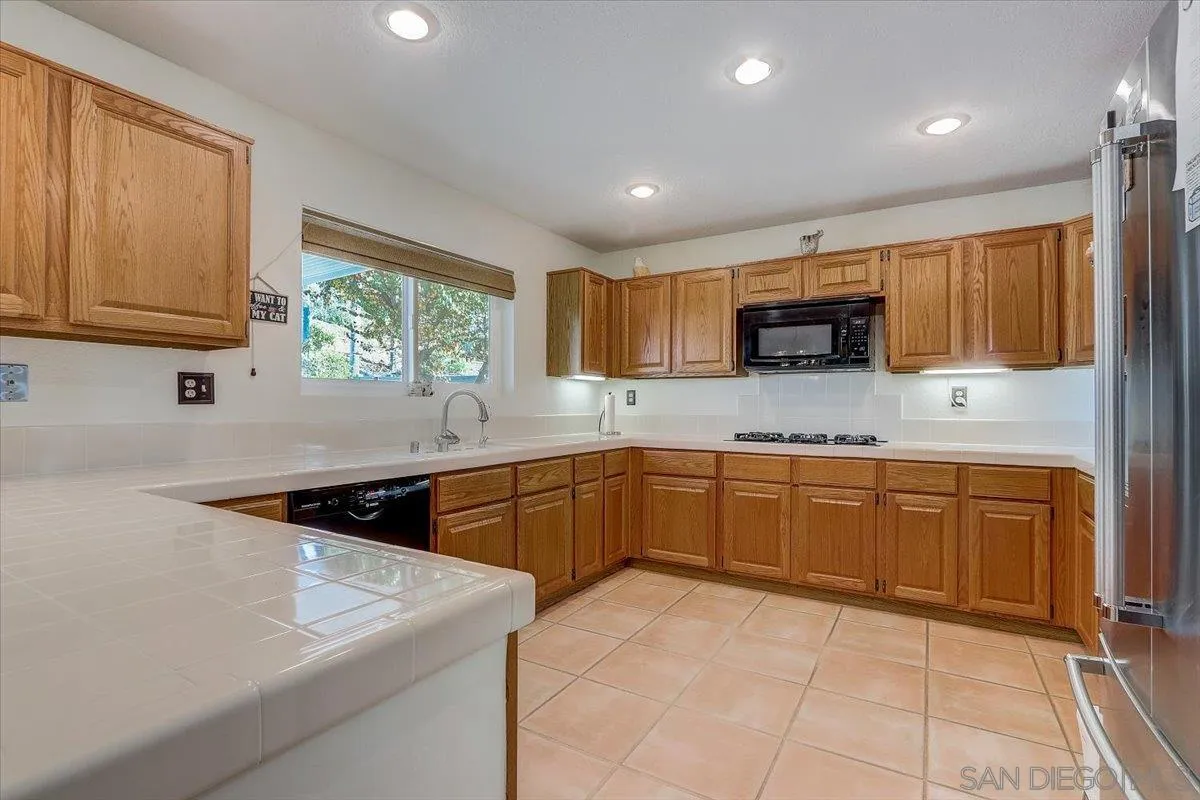 14381 Silver Heights Road Poway, CA 92064 - Photo 25 of 56 a kitchen with stainless steel appliances granite countertop a sink and a stove