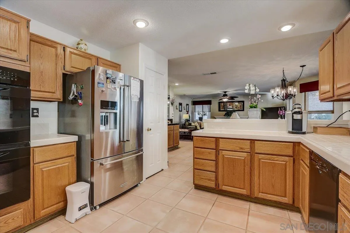 14381 Silver Heights Road Poway, CA 92064 - Photo 26 of 56 a kitchen with stainless steel appliances a refrigerator sink and cabinets