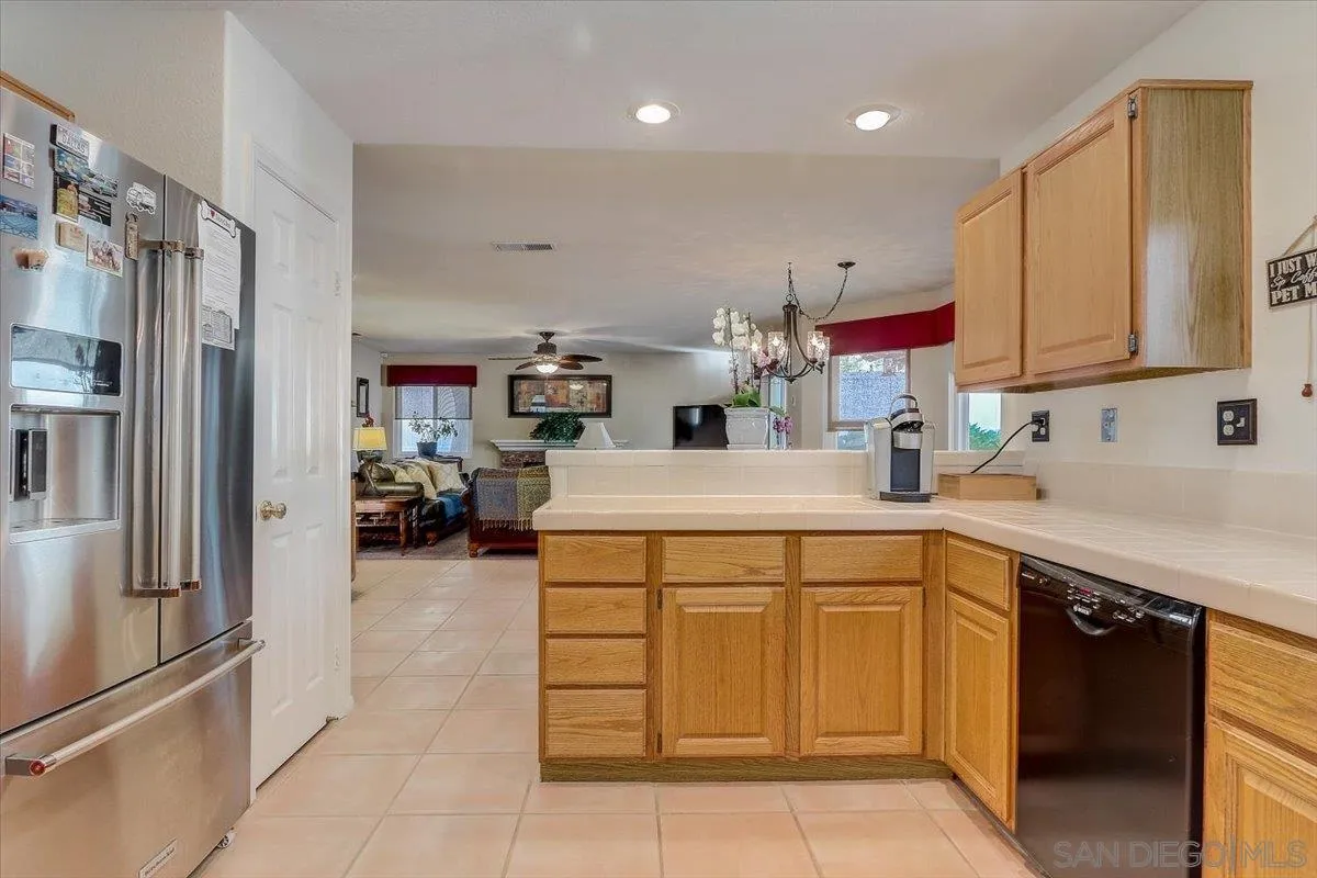 14381 Silver Heights Road Poway, CA 92064 - Photo 27 of 56 a kitchen with a sink refrigerator and cabinets