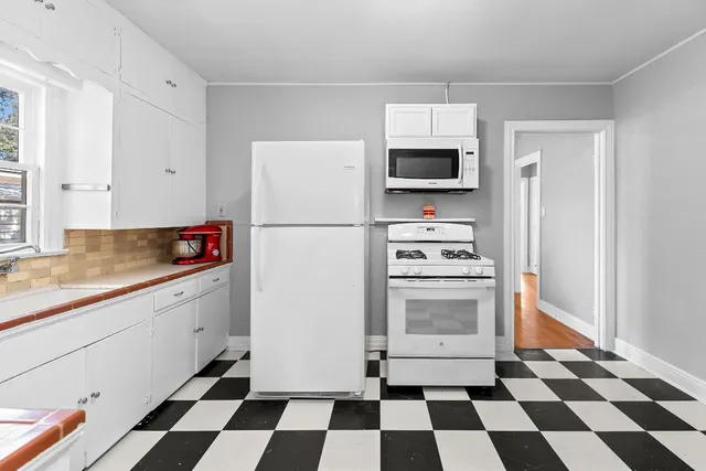 a kitchen with a refrigerator a stove and a microwave