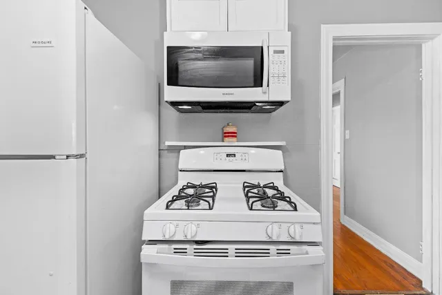 a white stove top oven sitting inside of a kitchen