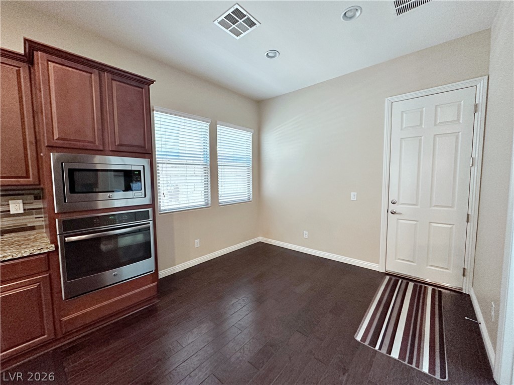 71 Newton Ridge Way Las Vegas, NV 89183 - Photo 14 of 40 Functional kitchen corner with modern stainless steel appliances and rich hardwood flooring.