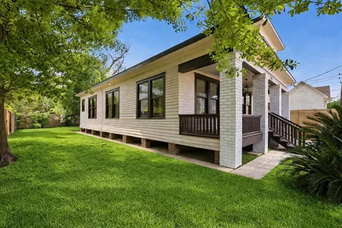 a view of a house with a backyard and wooden fence