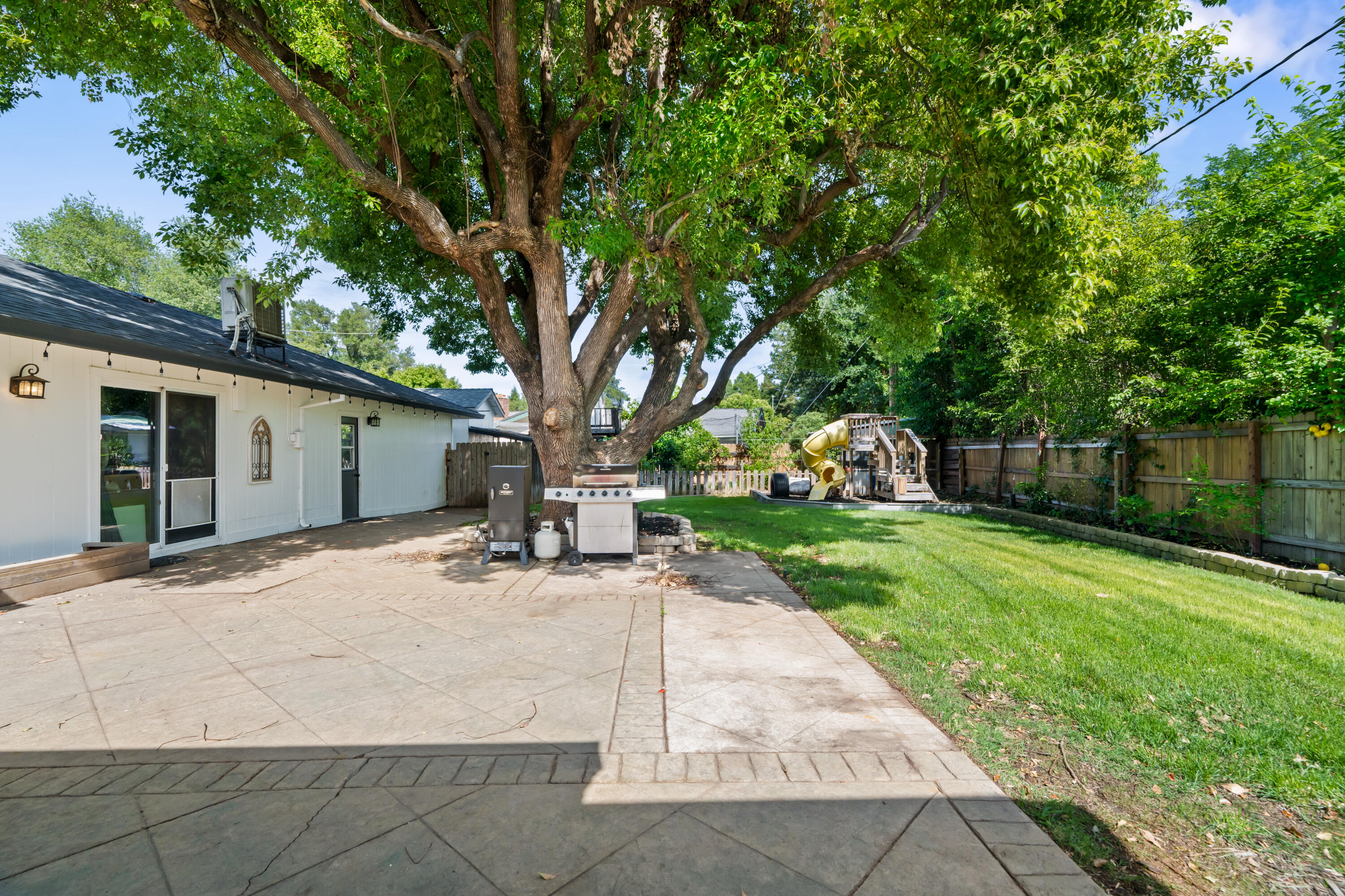 3689 Suzanne Way Redding, CA 96002 - Photo 41 of 46 a backyard of a house with table and chairs plants and large tree