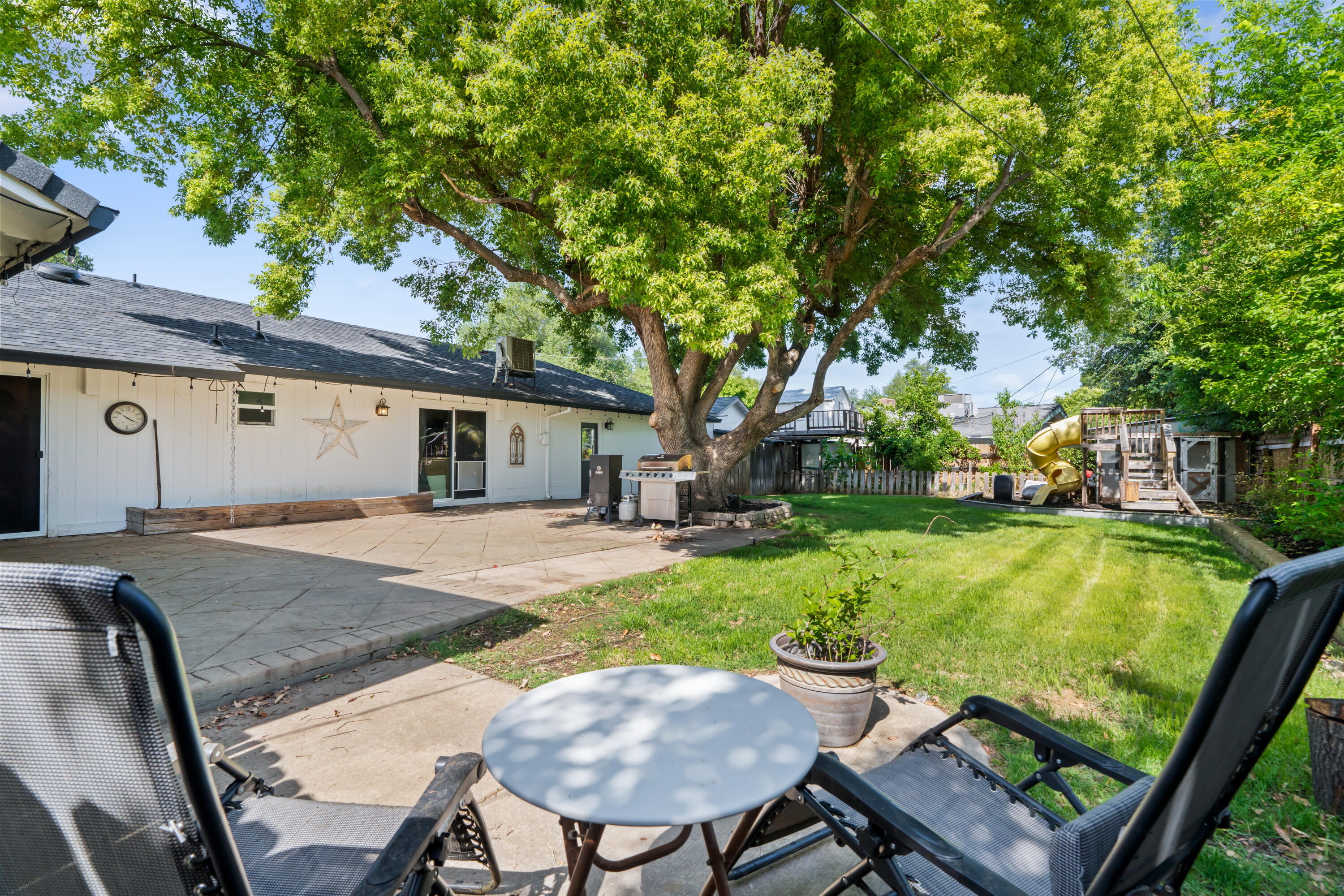3689 Suzanne Way Redding, CA 96002 - Photo 44 of 46 a view of a patio with table and chairs with wooden fence and plants