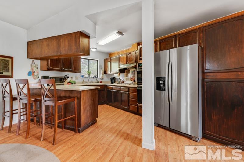 60 Rodeo Drive Reno, NV 89508 - Photo 9 of 37 a kitchen with stainless steel appliances a refrigerator a stove a sink a dining table and chairs