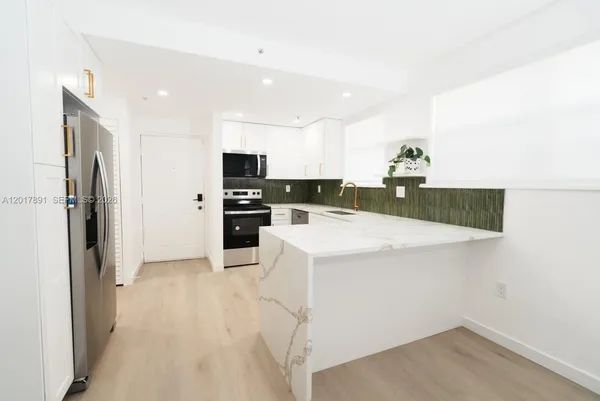 a kitchen with granite countertop a refrigerator and a sink