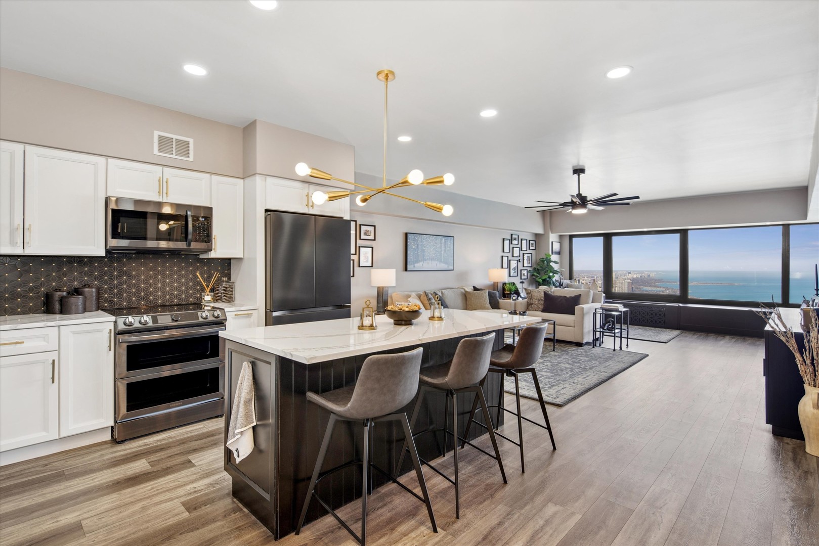 175 East Delaware Place, Unit 7304 Chicago, IL 60611 - Photo 12 of 36 a kitchen with stainless steel appliances kitchen island granite countertop a stove a refrigerator a sink a dining table and chairs with wooden floor