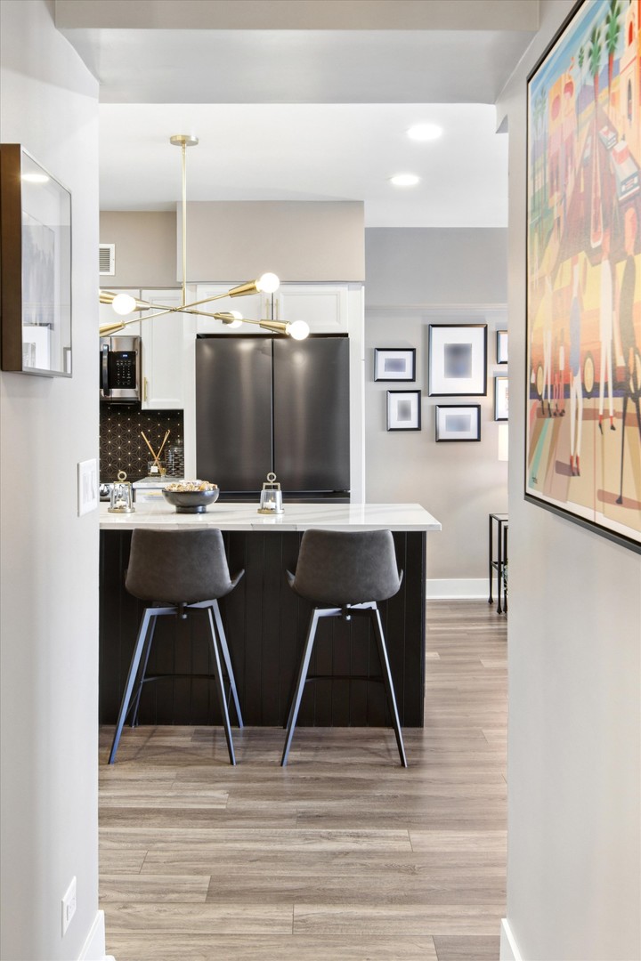 175 East Delaware Place, Unit 7304 Chicago, IL 60611 - Photo 14 of 36 a living room with stainless steel appliances kitchen island granite countertop a table chairs and a refrigerator