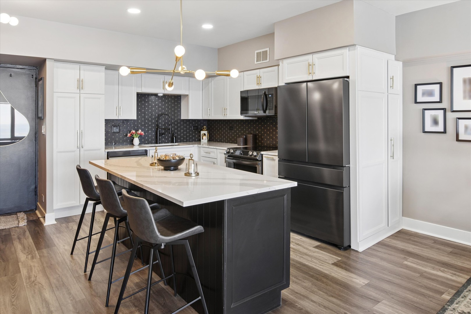 175 East Delaware Place, Unit 7304 Chicago, IL 60611 - Photo 9 of 36 a kitchen with stainless steel appliances a refrigerator a stove a sink and white cabinets with wooden floor