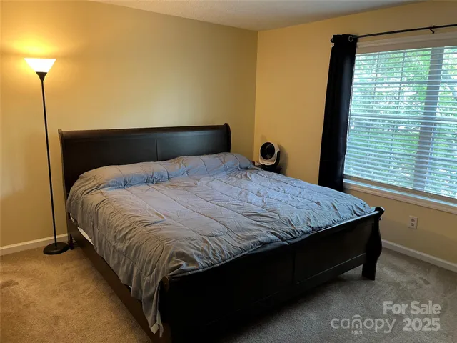 a bed sitting in a bedroom next to a window