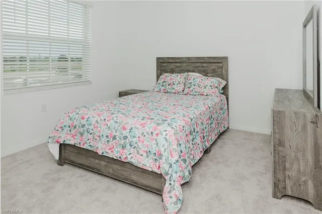 a bed sitting in a bedroom next to a window