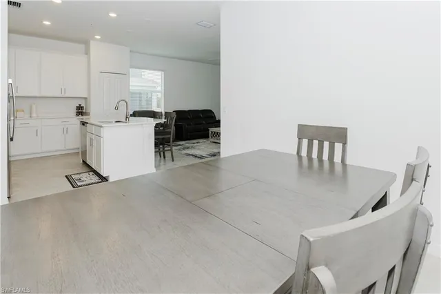 a kitchen with a table chairs a microwave a stove and a refrigerator with cabinets