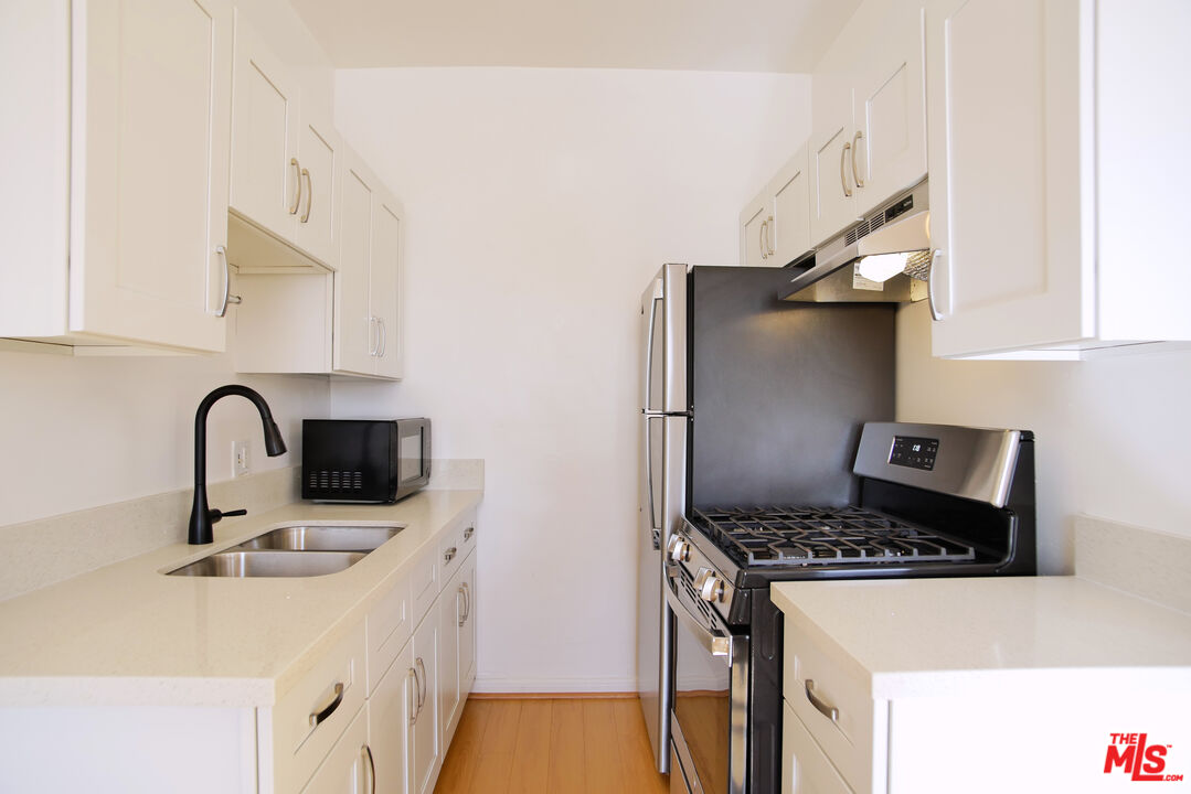 611 South Cloverdale Avenue, Unit 305 Los Angeles, CA 90036 - Photo 12 of 18 a kitchen with stainless steel appliances granite countertop a sink stove and refrigerator