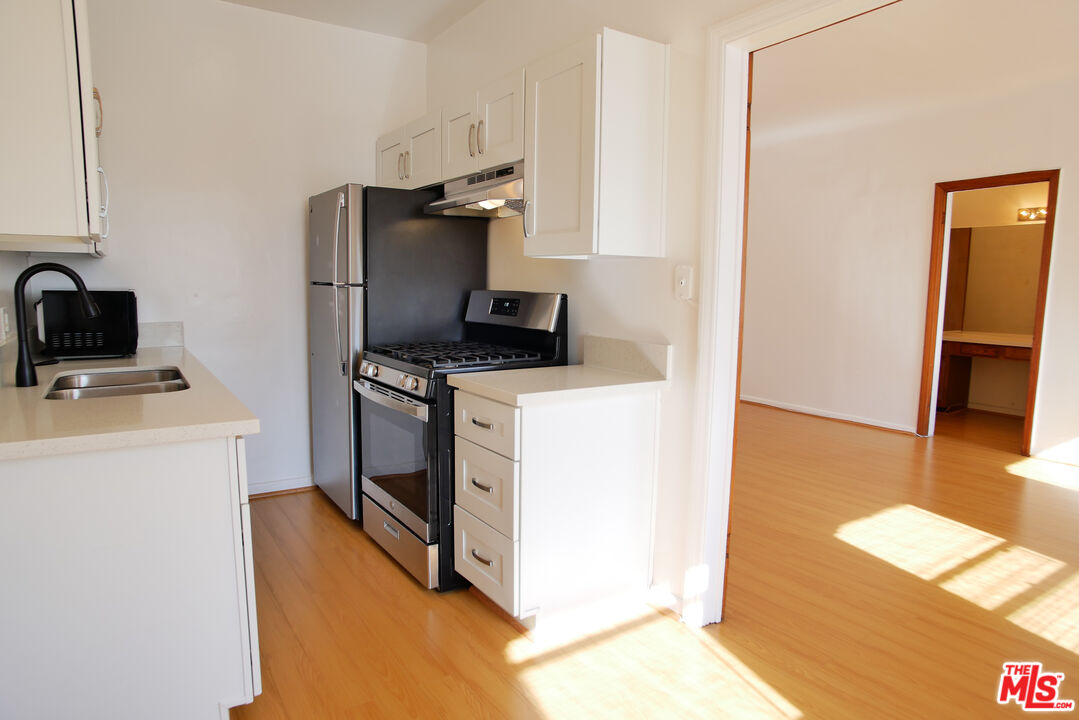 611 South Cloverdale Avenue, Unit 305 Los Angeles, CA 90036 - Photo 13 of 18 a kitchen with a refrigerator stove and microwave