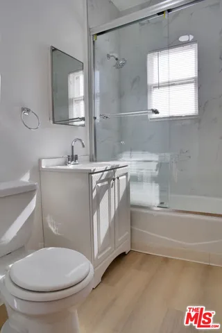 a bathroom with a granite countertop sink a mirror and a shower