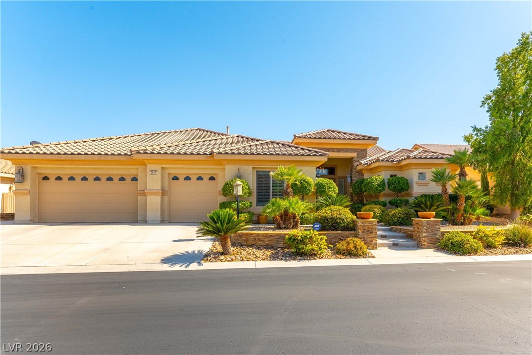 A well-maintained desert landscape frames this single-story residence with a multi-car garage and tiled roof.