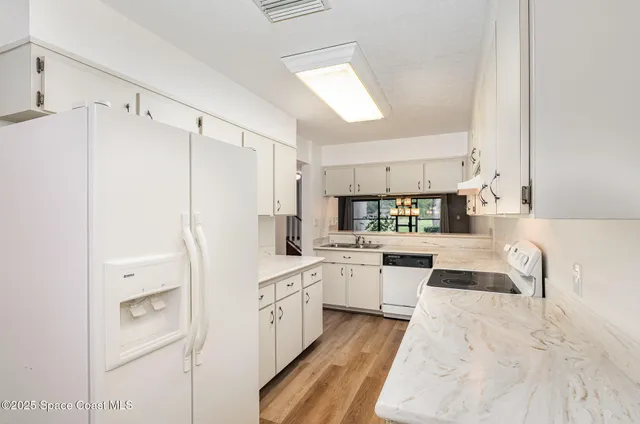 a kitchen with white cabinets and white appliances