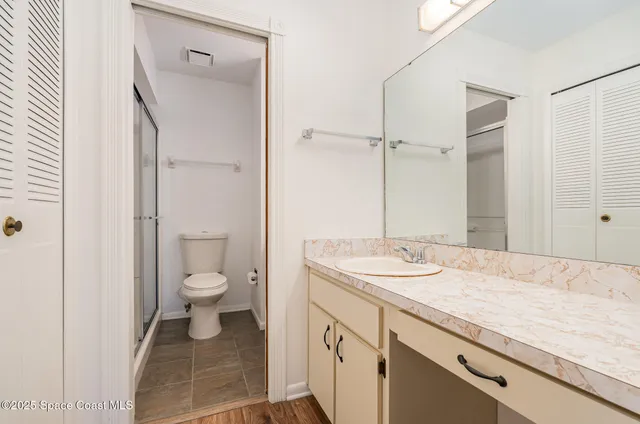 a bathroom with a granite countertop sink toilet and shower
