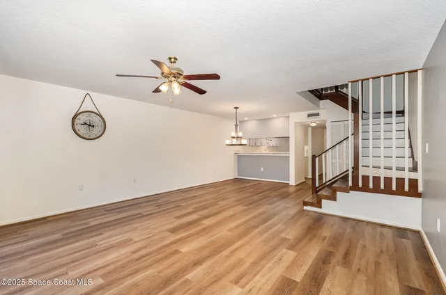 a view of a livingroom with a hardwood floor and a ceiling fan