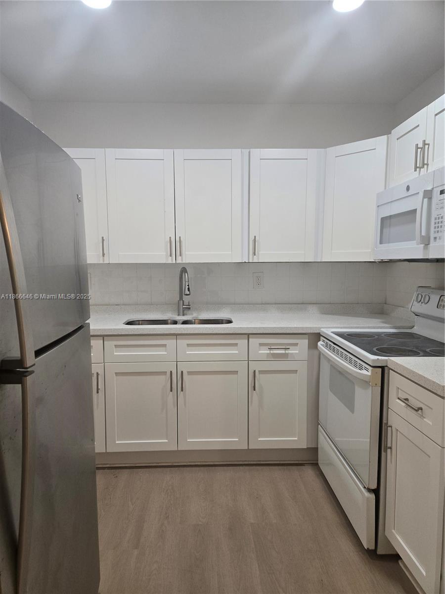 190 Southeast 12th Avenue, Unit 8B Pompano Beach, FL 33060 - Photo 2 of 5 a kitchen with granite countertop cabinets stainless steel appliances and a sink