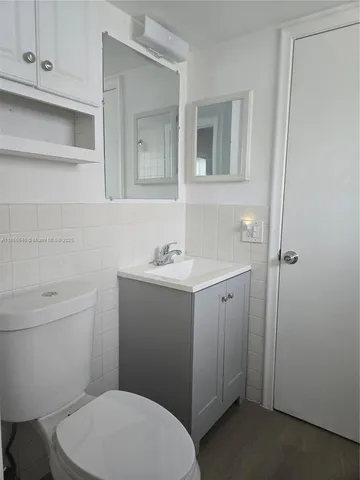 a bathroom with a toilet a sink and mirror