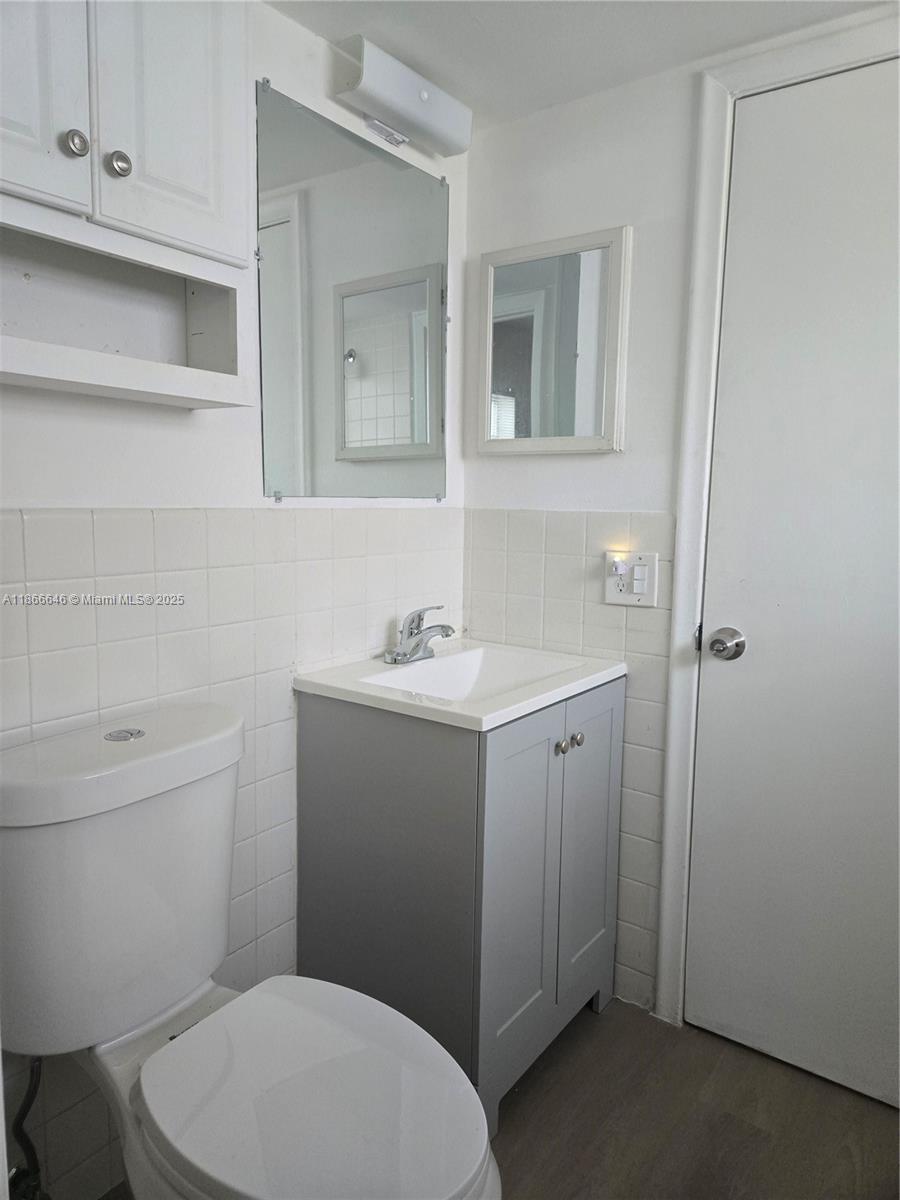 190 Southeast 12th Avenue, Unit 8B Pompano Beach, FL 33060 - Photo 3 of 5 a bathroom with a toilet a sink and mirror