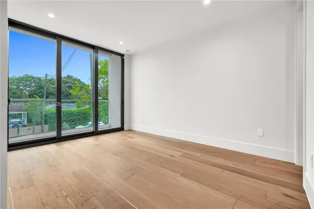 a view of a big room with wooden floor and windows
