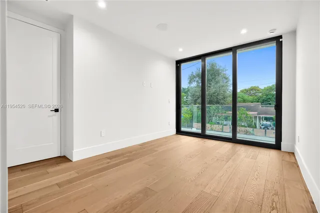 a view of a big room with wooden floor and windows