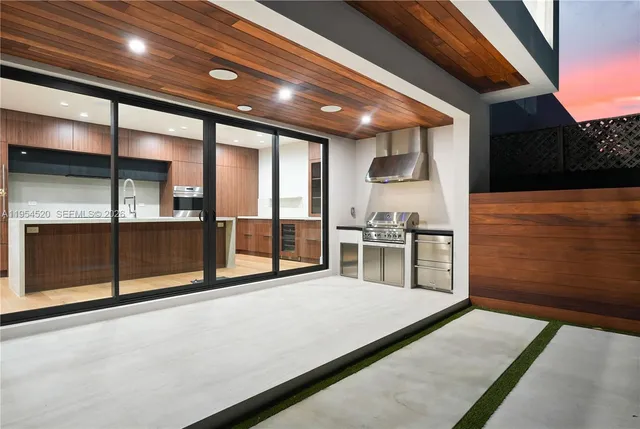 a view of a kitchen with stainless steel appliances a large counter top oven and cabinets