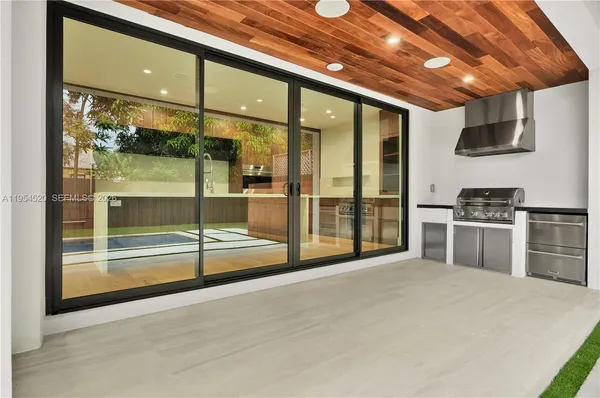 a room with stainless steel appliances wooden floor and windows