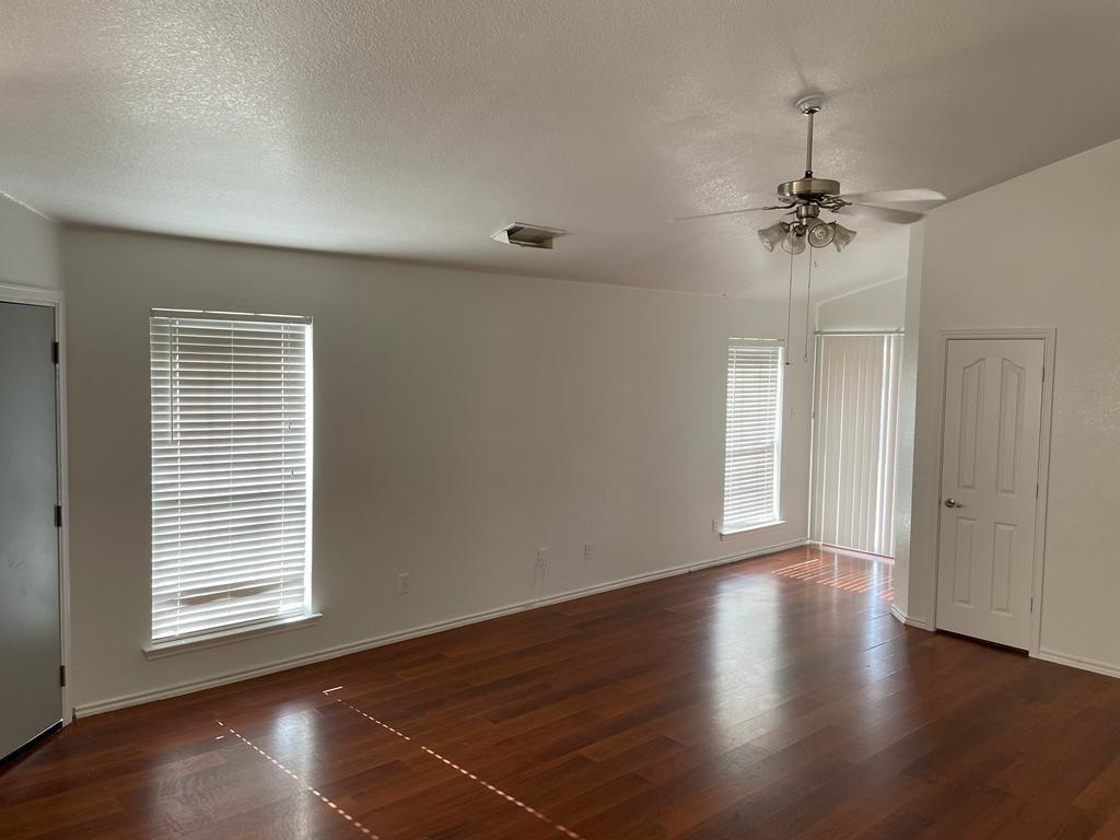 6324 Geneva Lane Fort Worth, TX 76131 - Photo 3 of 18 an empty room with wooden floor chandelier fan and windows