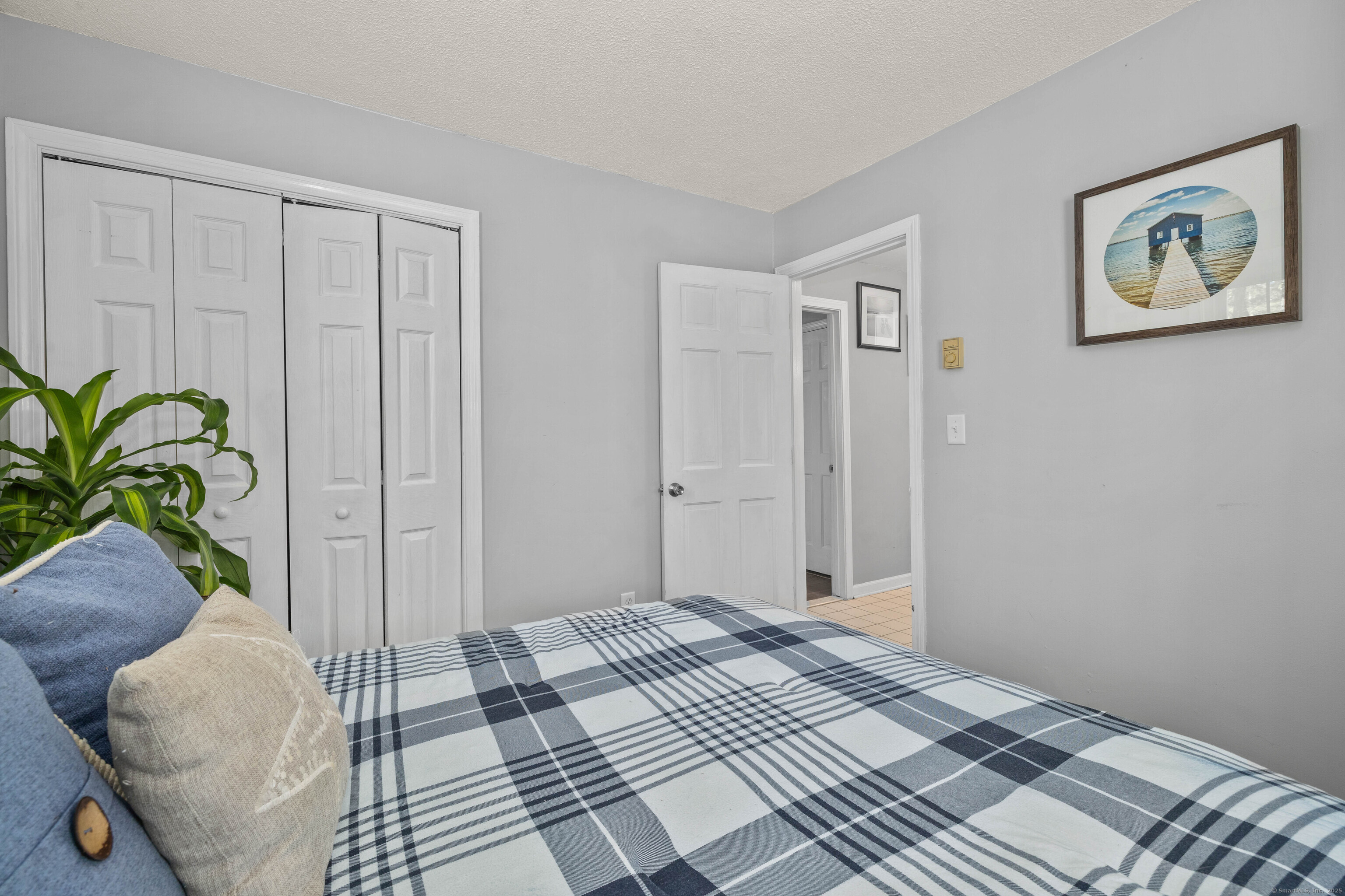 779 Summer Hill Road Madison, CT 06443 - Photo 27 of 40 a view of a bedroom with wooden floor and a potted plant
