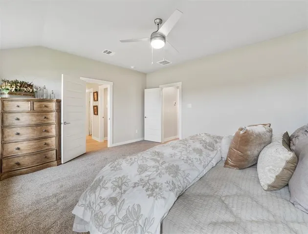 a spacious bedroom with a bed and a ceiling fan