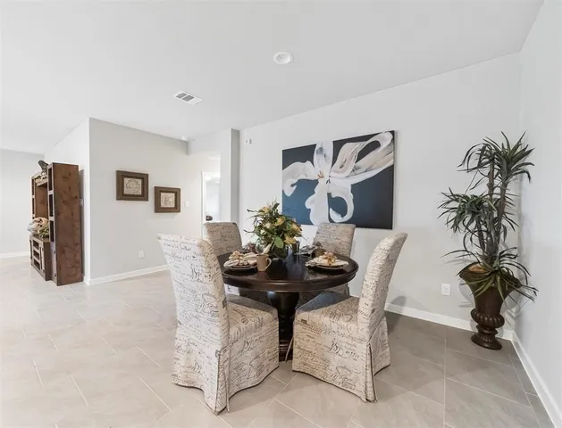 a dining room with furniture and potted plants