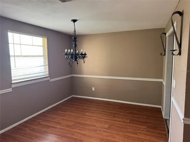 a view of a room with wooden floor and a window