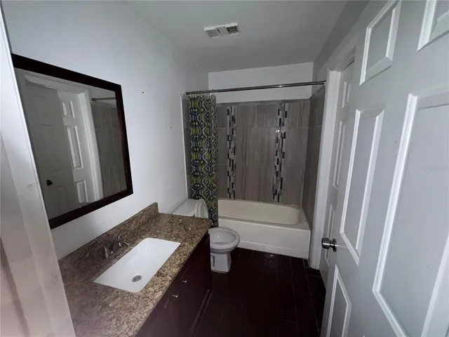 a bathroom with a sink a toilet a mirror and shower