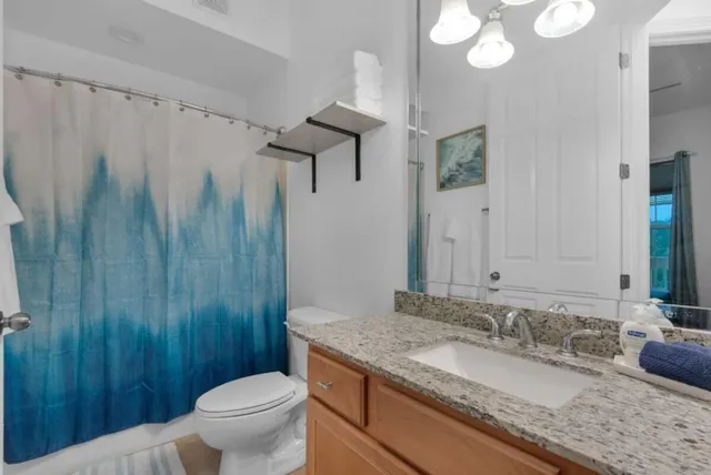 a bathroom with a granite countertop sink toilet and shower