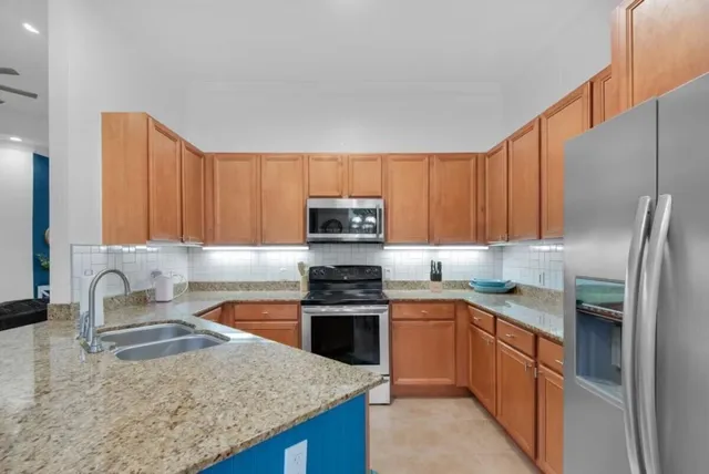 a kitchen with stainless steel appliances granite countertop a sink stove and refrigerator