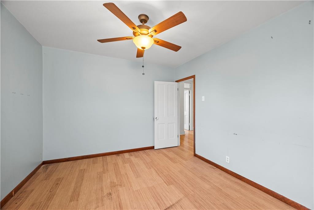 1276 Willowbrook Road Rostraver Township, PA 15012 - Photo 21 of 40 an empty room with wooden floor and a ceiling fan