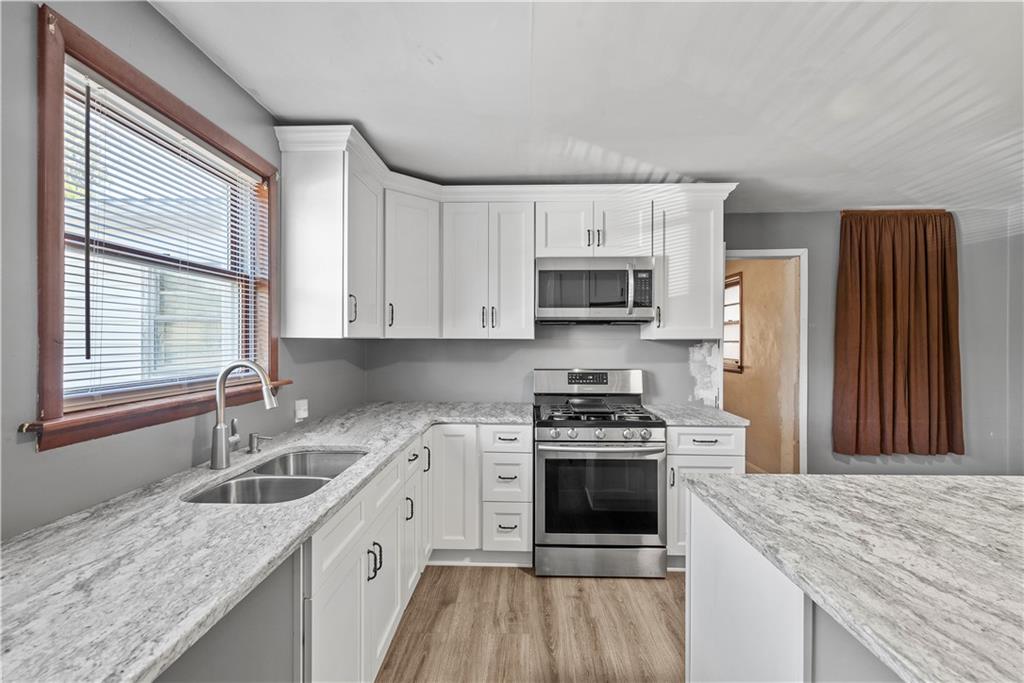 1276 Willowbrook Road Rostraver Township, PA 15012 - Photo 7 of 40 a kitchen with stainless steel appliances granite countertop a stove a sink dishwasher and a refrigerator