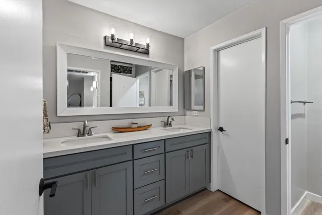 a bathroom with a double vanity sink and mirror