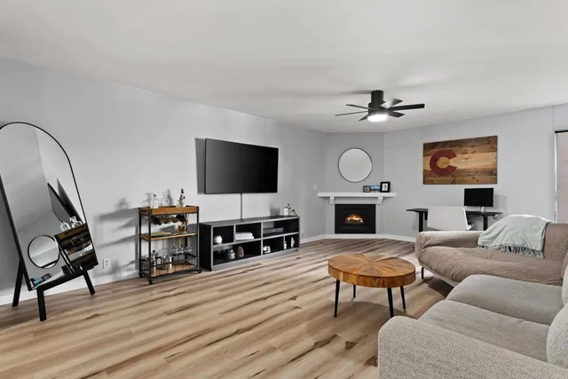 a living room with furniture a fireplace a flat screen tv and wooden floor