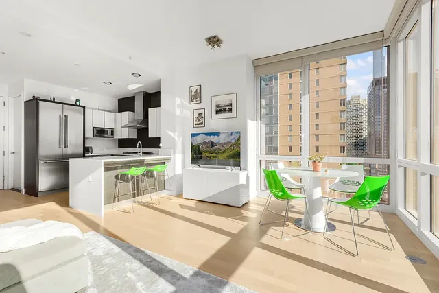 a large kitchen with kitchen island a large window in it
