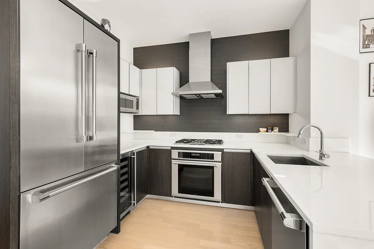 247 West 46th Street, Unit 4104 Manhattan, NY 10036 - Photo 3 of 7 a kitchen with a stove sink and refrigerator